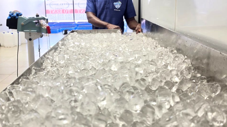 Water is Life staff scooping fresh gourmet ice cubes at the production table